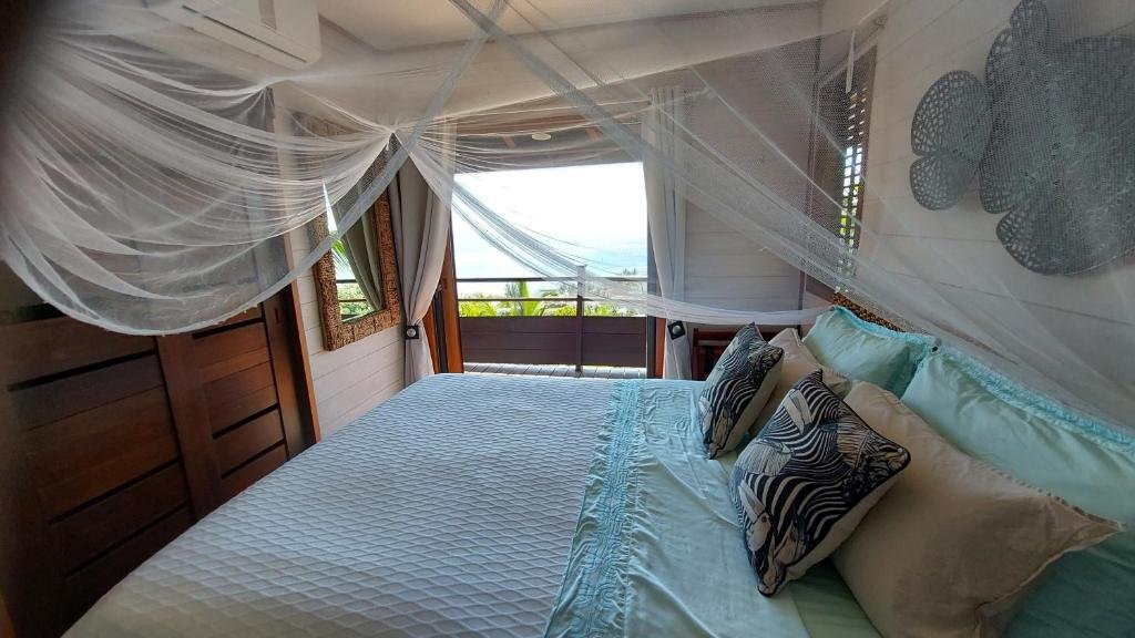 Bedroom with mosquito net and ocean view